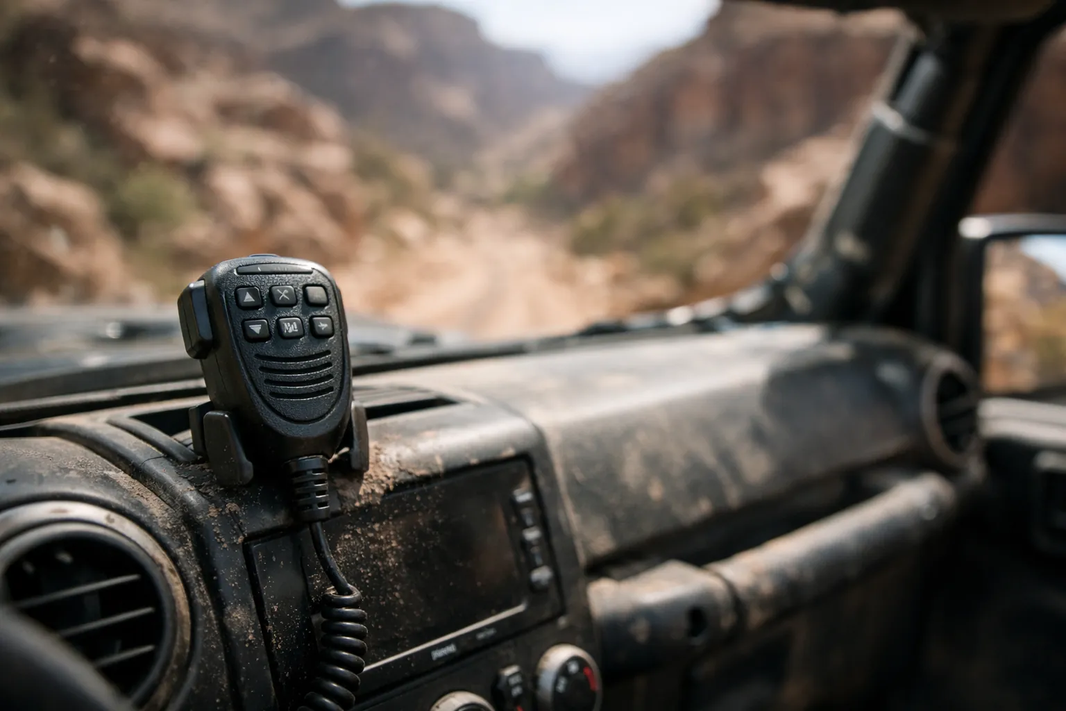 A radio hand mic clipped to the dash of an open-top off-road vehicle